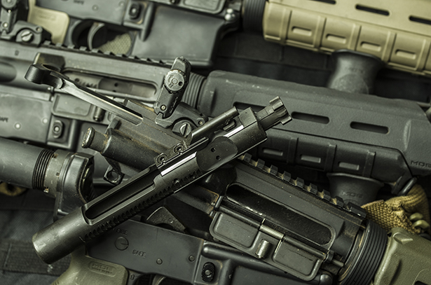 The reciprocating components were fairly standard AR-15 parts which proved to be up to the task. A stack of AR-15 carbines used in the brass vs. steel testing.